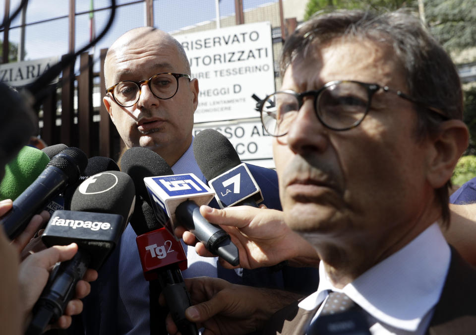 Fabio Alonso, left, and Francesco Petrelli, lawyers of American teenager Gabriel Natale-Hjorth, speak to reporters outside Rome's courthouse, Monday, Sept. 16, 2019. The lawyers for one of two American teenagers being held in the July slaying of the police officer have dropped a request for their client Natale-Hjorth to be released, saying they need more time to study new evidence emerged from the investigation. (AP Photo/Gregorio Borgia)