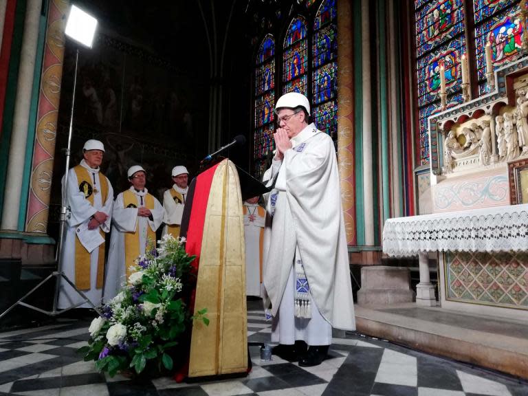 A priest wearing a hard hat has presided over Notre Dame‘s first mass since a fire devastated the ancient building two months ago.Michel Aupetit, the archbishop of Paris, welcomed 30 worshippers into the landmark gothic cathedral on Saturday.A congregation mainly made up of priests and church employees stood in a side chapel behind the choir stalls, which officials had deemed a safe location.It remains unclear when Notre Dame will officially reopen to the public.The priests were permitted to gather for its annual Dedication Mass, to commemorate the cathedral’s consecration.“This cathedral is a place of worship, it is its very own and unique purpose,” Mr Aupetit said.One French priest called the service “a true happiness, full of hope.” “We will rebuild this cathedral. It will take time of course — a lot of money, lot of time, lot of work — but we will succeed,” said Pierre Vivares, one of the congregation.“Today it’s a small but a true victory against the disaster we have had.”It is still unclear what caused the blaze, which began on the evening of 15 April.The fire tore through the historic building’s roof, toppling the spire as shocked Parisians looked on.Emmanuel Macron, the French president, has promised to rebuild Notre Dame in five years and a campaign to fund the effort has attracted promises of donations.French billionaires, including Bernard Arnault and Francois Pinault, pledged to donate millions of euros to the cathedral in the aftermath of the fire.But a spokesperson claimed bigger donors had yet to pay a cent towards its restoration.“The big donors haven’t paid. Not a cent,” Andre Finot, a Notre Dame press official, said on Friday.“They want to know what exactly their money is being spent on and if they agree to it before they hand it over, and not just to pay employees’ salaries.”Some of the workers who are helping to repair the church were invited to Sunday’s service.For security reasons Mr Aupetit and others wore hard hats and the number of attendees was restricted.Other worshippers could watch the mass live on a Catholic TV station.The recording of the service showed some burnt wood but a famous statue of the Virgin Mary appeared intact.Franck Riester, France’s culture minister, said this week that Notre Dame remains in a “fragile” state, especially its vaulted ceiling, which is still at risk of collapsing.Additional reporting by agencies