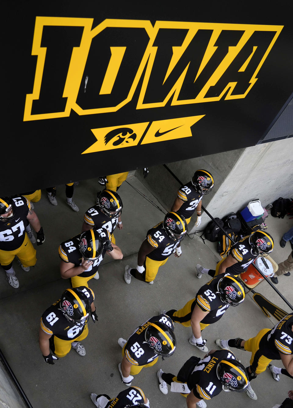 FILE - Members of the Iowa football team take the field prior to kickoff against Rutgers in an NCAA college football game, Saturday, Nov. 11, 2023, in Iowa City, Iowa. An Iowa criminal investigator suggested to colleagues last year that busting college athletes for online sports betting would impress the public and “the powers that be” and also nudge the state legislature toward updating gambling laws. Five starters on the Iowa State football team and a number of Iowa football and basketball players were among athletes criminally charged or suspended by the NCAA. (AP Photo/Bryon Houlgrave, File)