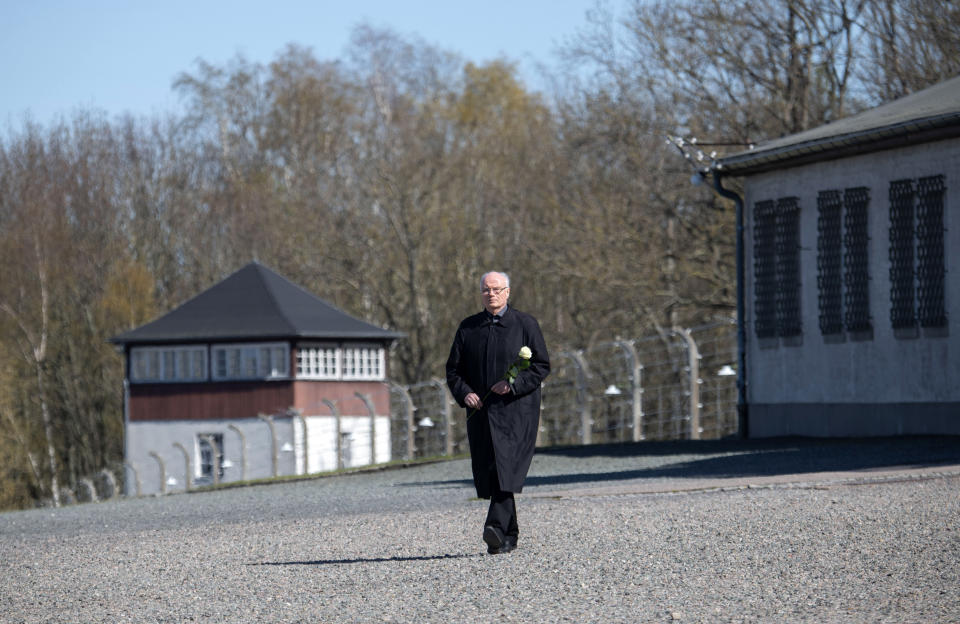 Volkhard Knigge, foundation director of the Nazi concentration camp Buchenwald memorial place, walks alone at the camp area prior he laying down a flower during a minute's silence in memory of the victims at the 75th anniversary of the liberation of the former Nazi concentration camp Buchenwald by the US Army near Weimar, Germany, Saturday, April 11, 2020. Because of Corona crisis, the memorial is currently closed and all commemoration ceremonies with survivors have been cancelled. For most people, the new coronavirus causes only mild or moderate symptoms, such as fever and cough. For some, especially older adults and people with existing health problems, it can cause more severe illness, including pneumonia. (AP Photo/Jens Meyer)