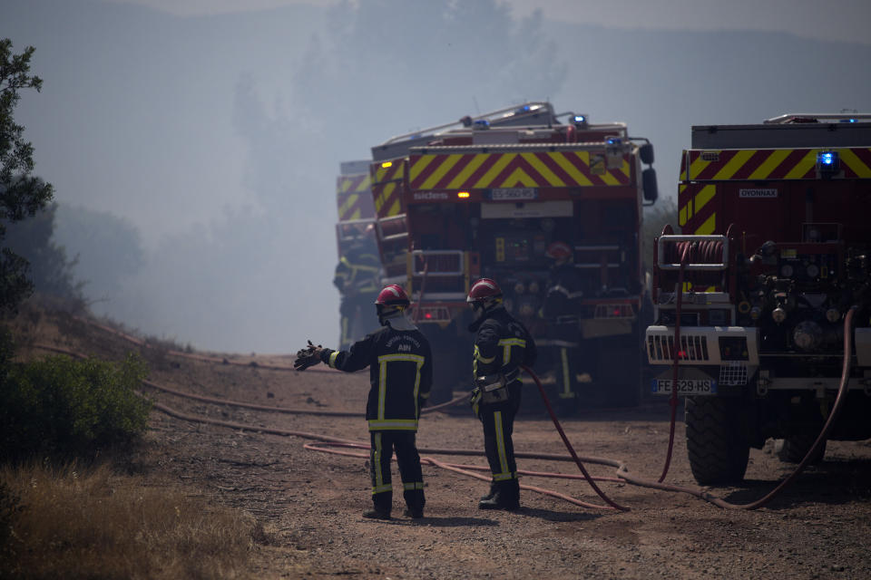 Firefighters work at a wildfire near Le Luc, southern France, Thursday, Aug. 19, 2021. A fire that has ravaged forests near the French Riviera for four days is slowing down as winds and hot weather subside, but more than 1,100 firefighters were still struggling to get it under control Thursday, local authorities said. (AP Photo/Daniel Cole)
