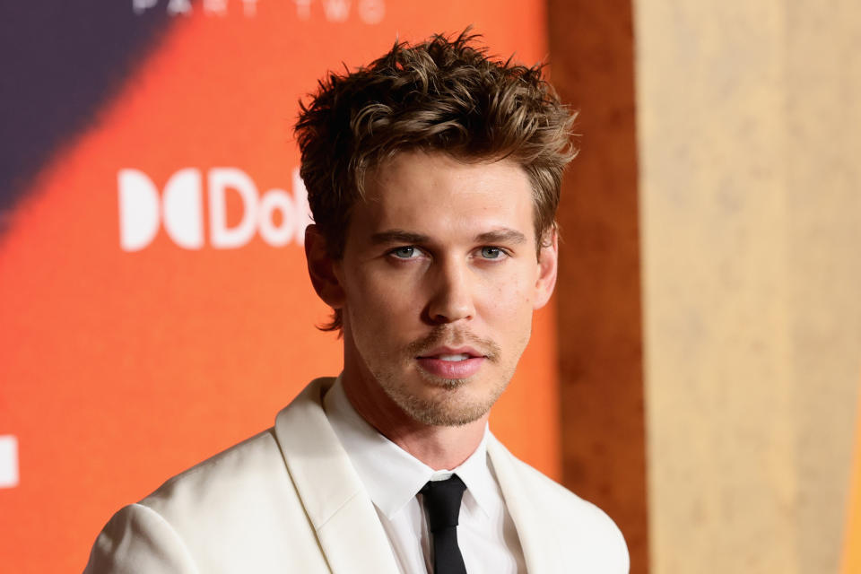 A close-up of Austin in a suit jacket at a media event