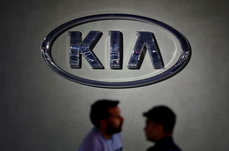 FILE PHOTO: Visitors walk past the logo of Kia Motors at its pavilion at the India Auto Expo 2020