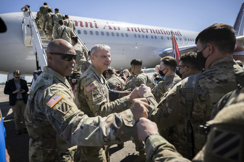 Command Sergeant Major Quentin Fenderson, center, and Major General Charles Costanza fist bump soldiers with the U.S. Army 3rd Infantry Division, 1st Armored Brigade Combat Team as they board an airplane at Hunter Army Airfield during their deployment to Germany, Wednesday March 2, 2022 in Savannah, Ga. The division is sending 3,800 troops as reinforcements for various NATO allies in Eastern Europe. (Stephen B. Morton /Atlanta Journal-Constitution via AP)