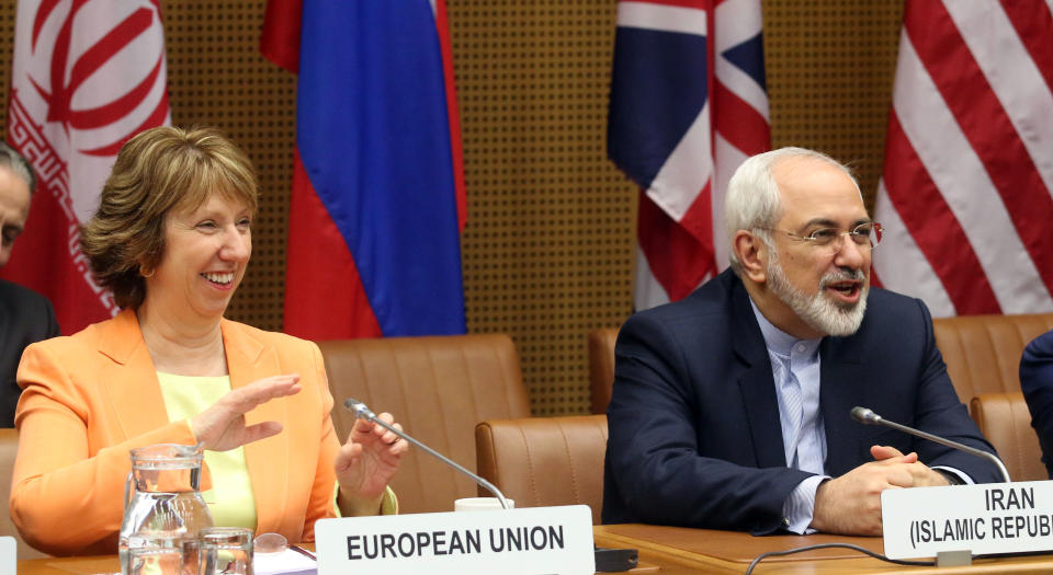 European foreign policy chief Catherine Ashton, left, and Iranian Foreign Minister Mohamad Javad Zarif, right, wait for the start of closed-door nuclear talks in Vienna, Austria, Wednesday, March 19, 2014. Iran and six world powers appear to be tackling less sensitive issues first at nuclear talks meant to curb Tehran's atomic activities in exchange for full sanctions relief. Iran's official IRNA news agency says Wednesday's talks are focusing on a heavy water reactor. The six want the nearly finished reactor shut down, or converted to a type that produces less plutonium, a material that could be used to make nuclear weapons. (AP Photo/Ronald Zak)