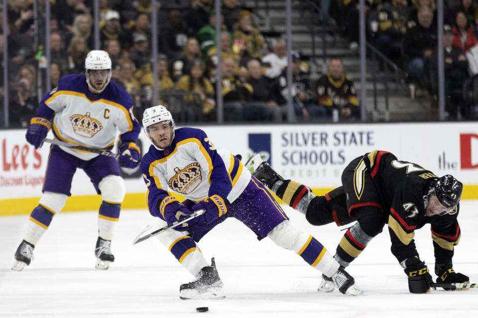 Los Angeles Kings defenseman Matt Roy (3) passes the puc, while Vegas Golden Knights center Paul Cotter (43) falls during the first period of an NHL hockey game Saturday, Jan. 7, 2023, in Las Vegas. (AP Photo/Ellen Schmidt)