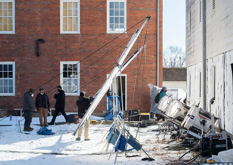 A lighting crew sets up lights and reflector panels for a scene in the granary at Old Economy Village for the filming of the Netflix movie, "The Pale Blue Eye" Friday in Ambridge.