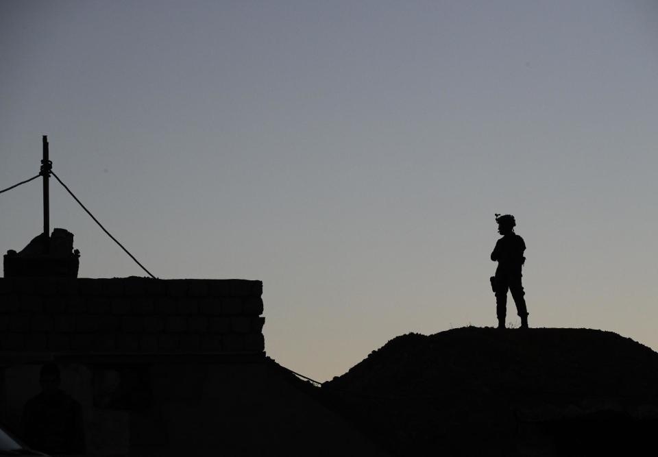 A Kurdish Peshmerga soldier is silhouetted while French President Francois Hollande visits a military outpost on the outskirts of the Islamic State-held city of Mosul, outside the Kurdish city of Irbil, Iraq, Monday, Jan. 2, 2017. Hollande is in Iraq for a one-day visit.(AP Photo/ Christophe Ena, Pool)