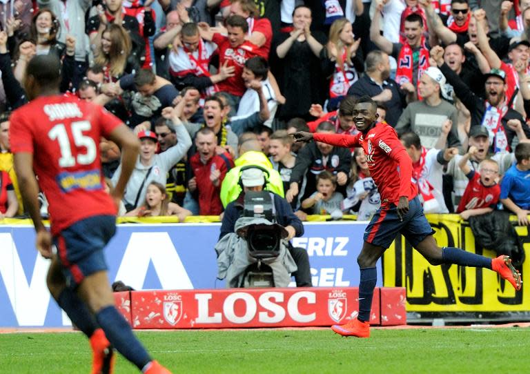 Lille's forward Adama Traore (R) celebrates after scoring a goal during the French L1 football match Lille vs Bordeaux on April 19, 2015