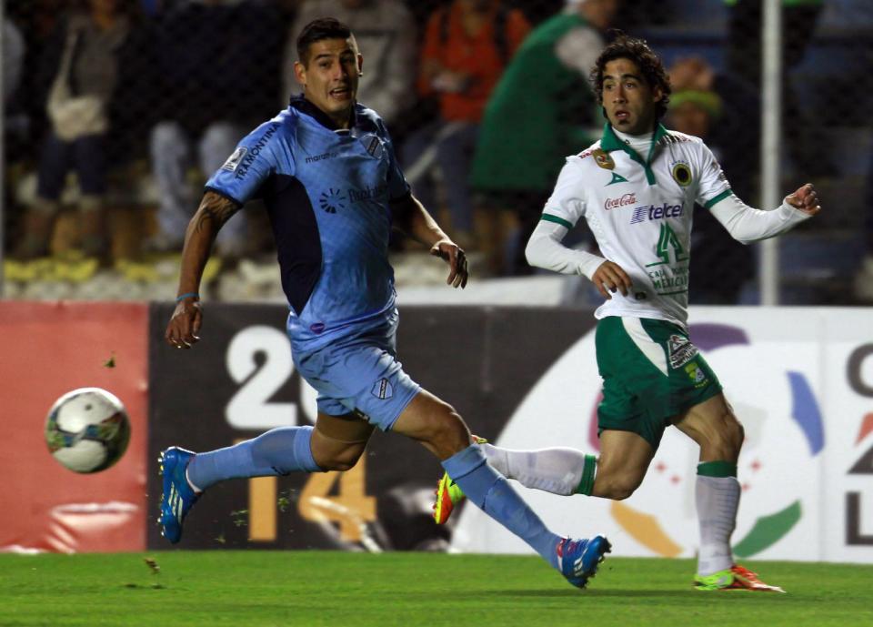 Matías Britos del León de México (derecha) disputa un balón con Nelson Cabrera del Bolívar boliviano en los cuartos de final de la Copa Libertadores el martes 22 de abril de 2014. (AP Foto/Juan Karita)