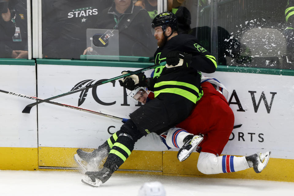 New York Rangers right wing Vitali Kravtsov is checked against the boards by Dallas Stars defenseman Jani Hakanpaa (2) during the second period of an NHL hockey game in Dallas, Saturday, Oct. 29, 2022. (AP Photo/Michael Ainsworth)
