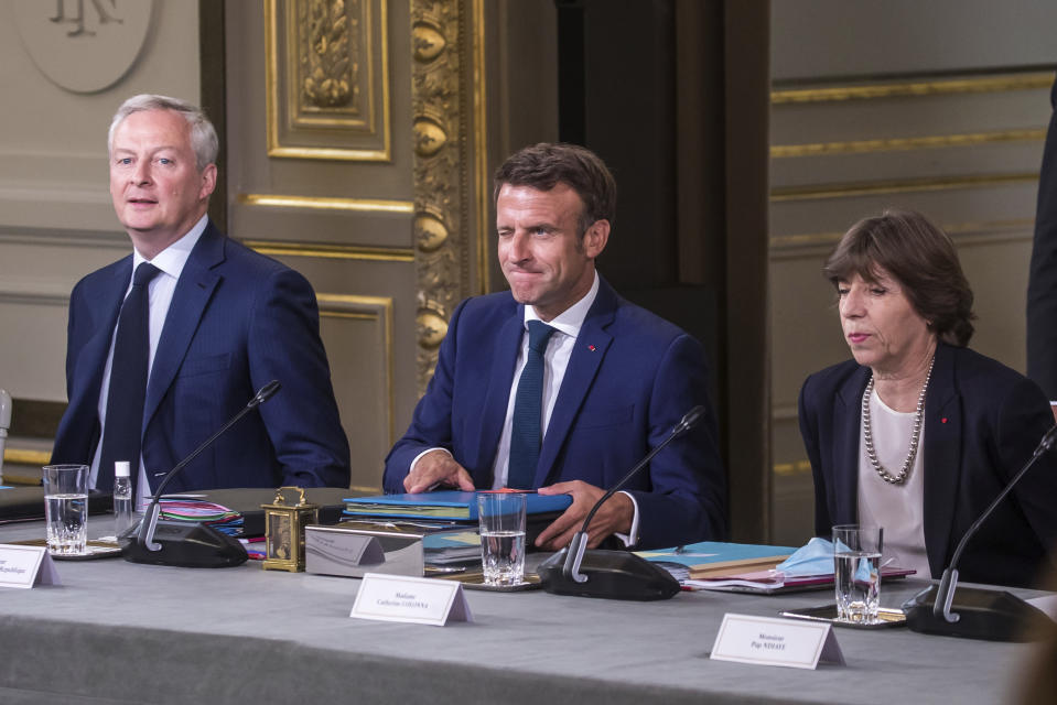 French President Emmanuel Macron, center, Economy Minister Bruno Le Maire, left, and and Foreign Minister Catherine Colonna attend the first cabinet meeting with new ministers at the Elysee Palace in Paris, Monday, July 4, 2022. French President Emmanuel Macron rearranged his Cabinet on Monday in an attempt to adjust to a new political reality following legislative elections in which his centrist alliance failed to win a majority in the parliament. (Christophe Petit Tesson, Pool via AP)