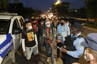 Police at a roadblock check the documents of migrants before allowing them to continue toward the Guatemalan border, on the highway leading to Choloma, Honduras, from San Pedro Sula, Thursday, Jan. 14, 2021. About 200 Honduran migrants resumed walking toward the U.S. border, a day before a migrant caravan was scheduled to depart the city of San Pedro Sula. (AP Photo/Delmer Martinez)