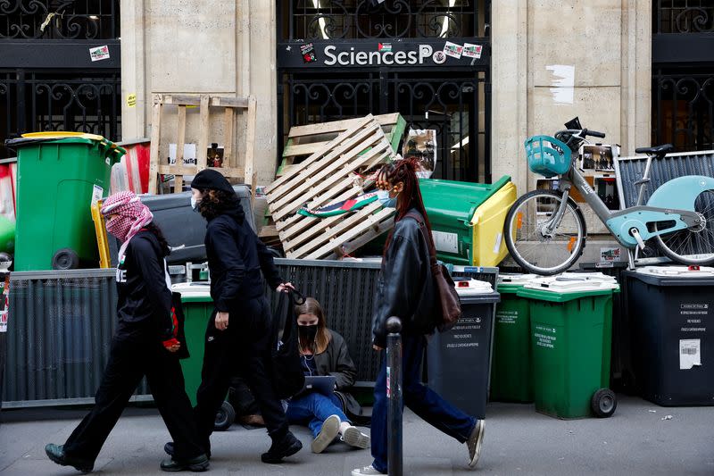 Masked youths take part in the occupation of a building of the Sciences Po University in support of Palestinians in Gaza, in Paris