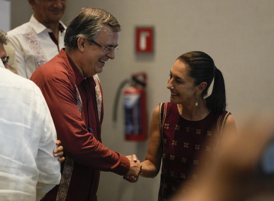 FILE - Expected presidential candidates of the MORENA ruling party, Mexico's Foreign Minister Marcelo Ebrard, left, and Mexico City's Mayor Claudia Sheinbaum shake hands during a news conference at a hotel in Mexico City, Sunday, June 11, 2023. According to polls, Sheinbaum is the favorite to become the ruling party´s official candidate for the next presidential elections, closely followed by Ebrard. (AP Photo/Fernando Llano, File)