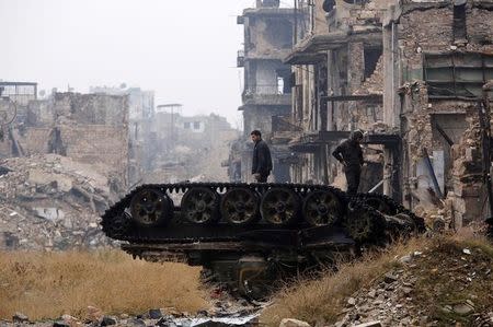 Forces loyal to Syria's President Bashar al-Assad stand atop a damaged tank near Umayyad mosque, in the government-controlled area of Aleppo, during a media tour, Syria December 13, 2016. REUTERS/Omar Sanadiki