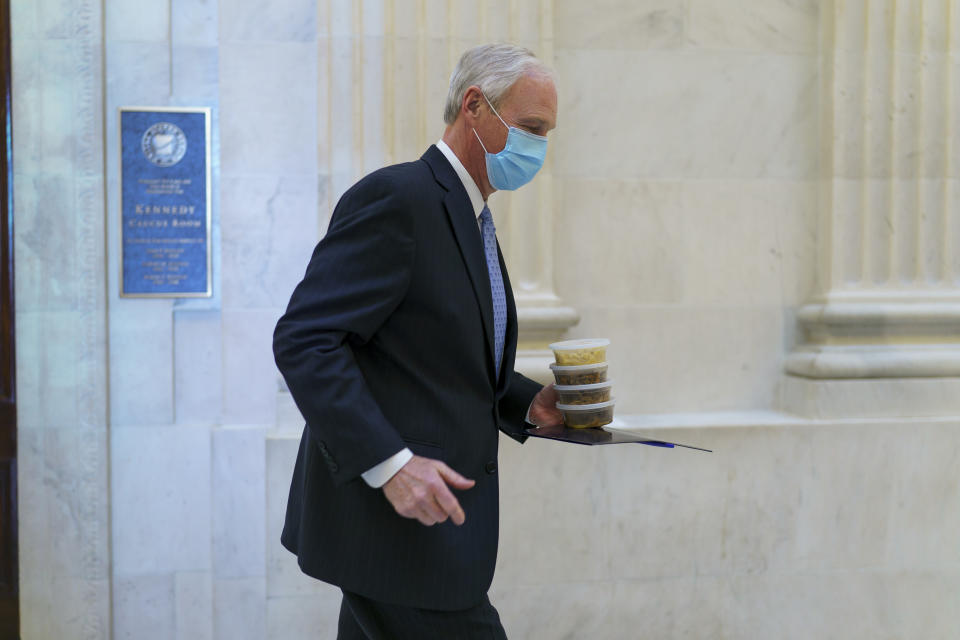 Sen. Ron Johnson, R-Wis., carries containers of food as he leaves a Senate Republican policy luncheon on Capitol Hill in Washington, Thursday, March 4, 2021. Johnson insisted that the entire text of the $1.9 trillion COVID relief bill be read aloud during its consideration. (AP Photo/J. Scott Applewhite)