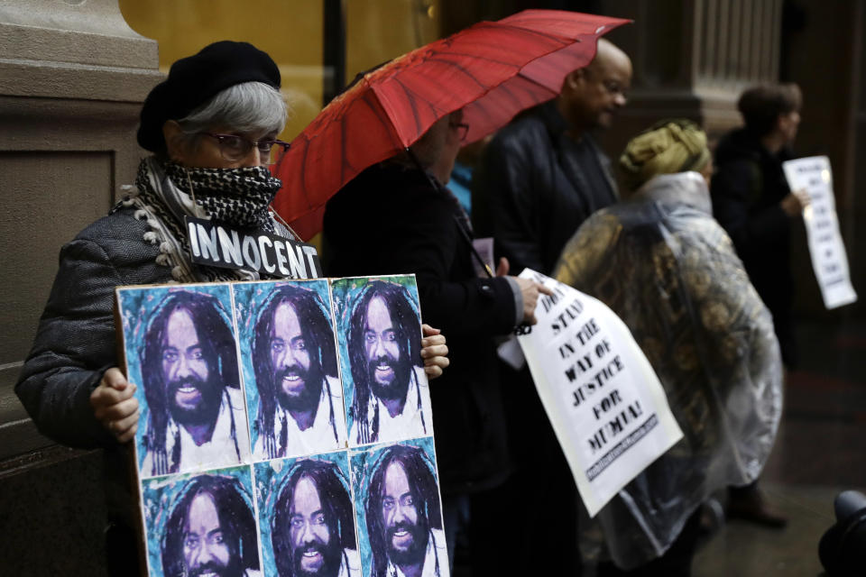 A protestor holds up a poster depicting Mumia Abu-Jamal during a demonstration outside the offices of District Attorney Larry Krasner, Friday, Dec. 28, 2018, in Philadelphia. A judge issued a split ruling Thursday that grants Abu-Jamal another chance to appeal his 1981 conviction in a Philadelphia police officer's death. (AP Photo/Matt Slocum)