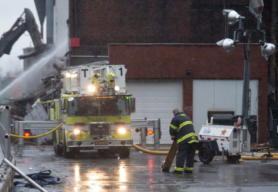 Firefighters continue to work to quell flames at the old mill in Kent on Saturday, 24 hours after the fire started.