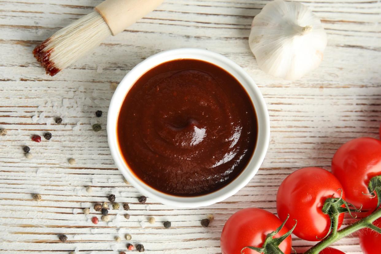 Flat lay composition with barbecue sauce on white wooden table