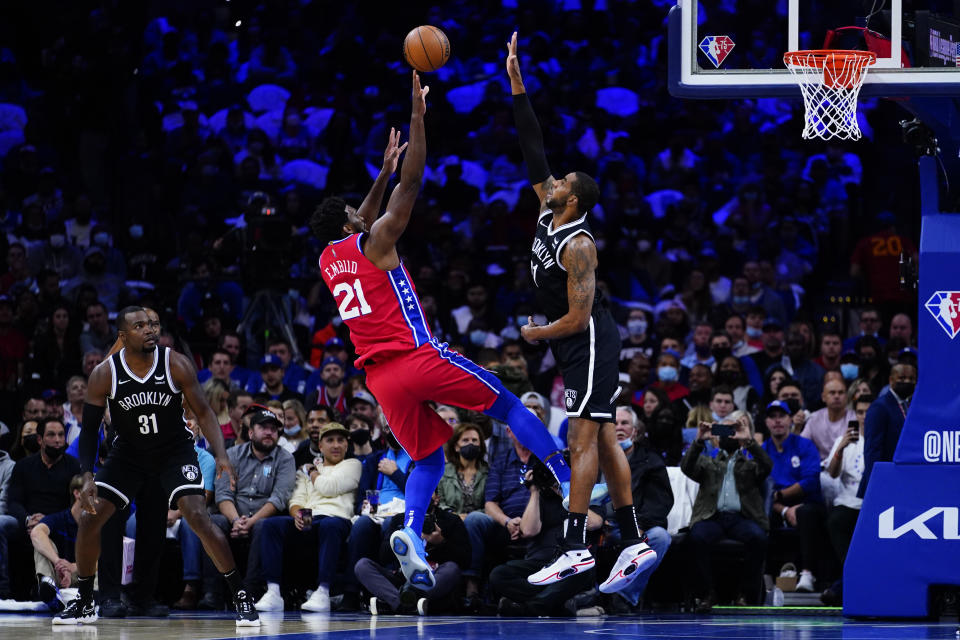 Philadelphia 76ers' Joel Embiid, center, goes up for a shot against Brooklyn Nets' LaMarcus Aldridge during the first half of an NBA basketball game, Friday, Oct. 22, 2021, in Philadelphia. (AP Photo/Matt Slocum)