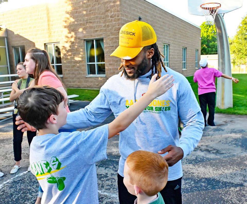 Green Bay Packers running back Aaron Jones hugs a youngster during the Yards For Shoes Campaign at a Boys & Girls Club of Greater Green Bay on Sept. 19 in Green Bay, Wisconsin.