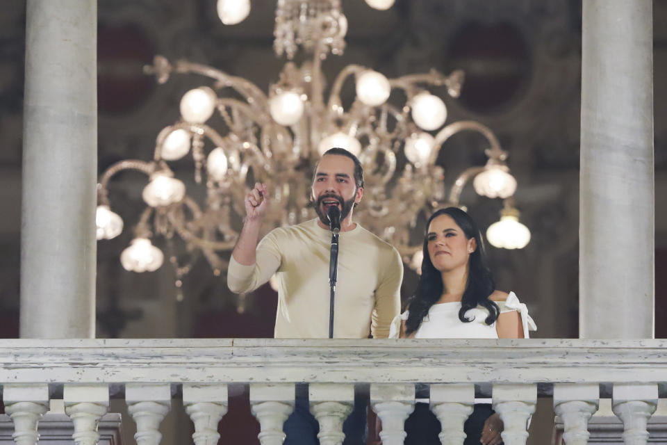 El Salvador President Nayib Bukele, left, accompanied by his wife Gabriela Rodriguez, speaks to supporters from the balcony of the presidential palace in San Salvador, El Salvador, after polls closed for general elections on Sunday, Feb. 4, 2024. (AP Photo/Salvador Melendez)