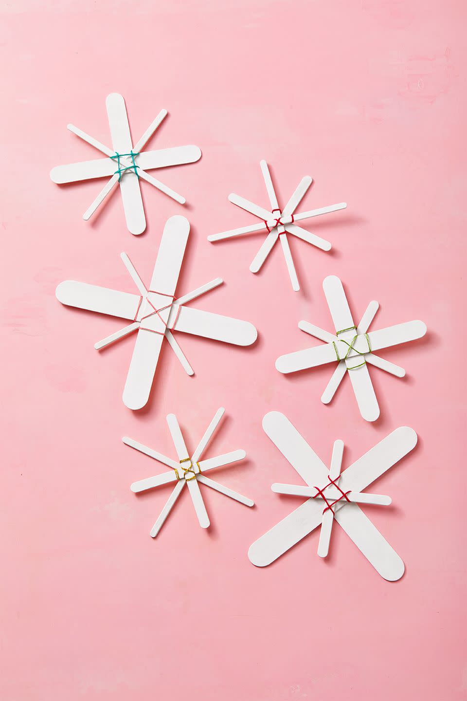 <p>Inspired by traditional Scandinavian straw ornaments, these popsicle stick ornaments are the perfect weekend activity. To make, paint popsicle sticks white and let dry. Arrange matching sizes into an X-shape and glue together in the middle. Arrange 2 X’s diagonally on top of each other to create a snowflake shape and glue in the middle. Let dry completely. Weave colored embroidery thread around the popsicle sticks to create an X or grid pattern. Tie the thread at the back of the snowflake and trim any excess. Glue a ribbon loop to the back of the snowflake to hang.</p>