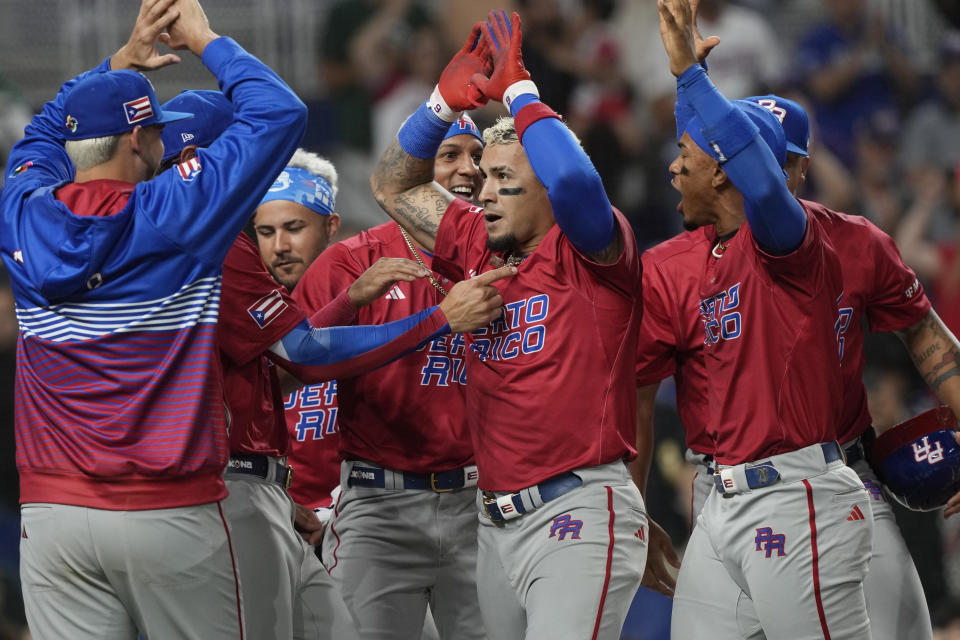 Puerto Rico's Javier Baez (9) is congratulated after hitting a home run during the first inning of a World Baseball Classic game against Mexico, Friday, March 17, 2023, in Miami. (AP Photo/Marta Lavandier)