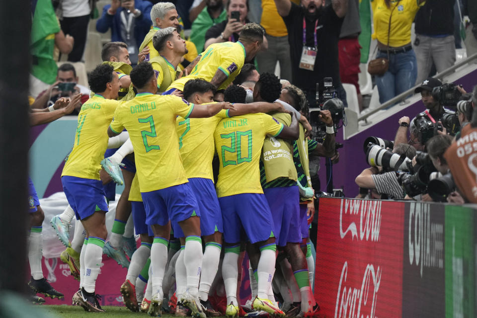 Brazil's Richarlison, hidden by teammates, celebrates after scoring during the World Cup group G soccer match between Brazil and Serbia, at the Lusail Stadium in Lusail, Qatar, Thursday, Nov. 24, 2022. (AP Photo/Aijaz Rahi)