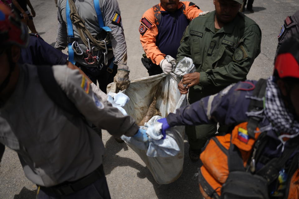 The body of seven-year-old Angel Senprum is brought to a community health center amid flooding in Las Tejerias, Venezuela, Monday, Oct. 10, 2022. A fatal landslide fueled by flooding and days of torrential rain swept through this town in central Venezuela. (AP Photo/Matias Delacroix)