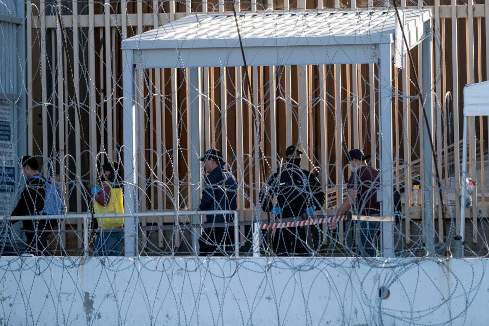 Commuters are seen walking to the United States wearing face masks as a preventive measure to avoid the spread of COVID-19 coronavirus, as a Customs and Border Protection agent looks on at San Ysidro crossing seen from Tijuana, Baja California state, Mexico, on April 23, 2020, on the US-Mexico border. - US President Donald Trump partially blocked immigration to the United States "to protect American workers" from the economic shock of the coronavirus, as the United Nations warned the world was facing "a humanitarian catastrophe". (Photo by Guillermo Arias / AFP) (Photo by GUILLERMO ARIAS/AFP via Getty Images)