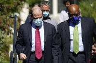 Colorado Gov. Jared Polis, left, confers with Rico Munn, superintendent of Aurora, Colo., Public Schools, as they head into a news conference about the increase in COVID-19 cases in the state and how parents need to enroll their children in school during the pandemic Tuesday, Sept. 29, 2020, in Denver. (AP Photo/David Zalubowski)