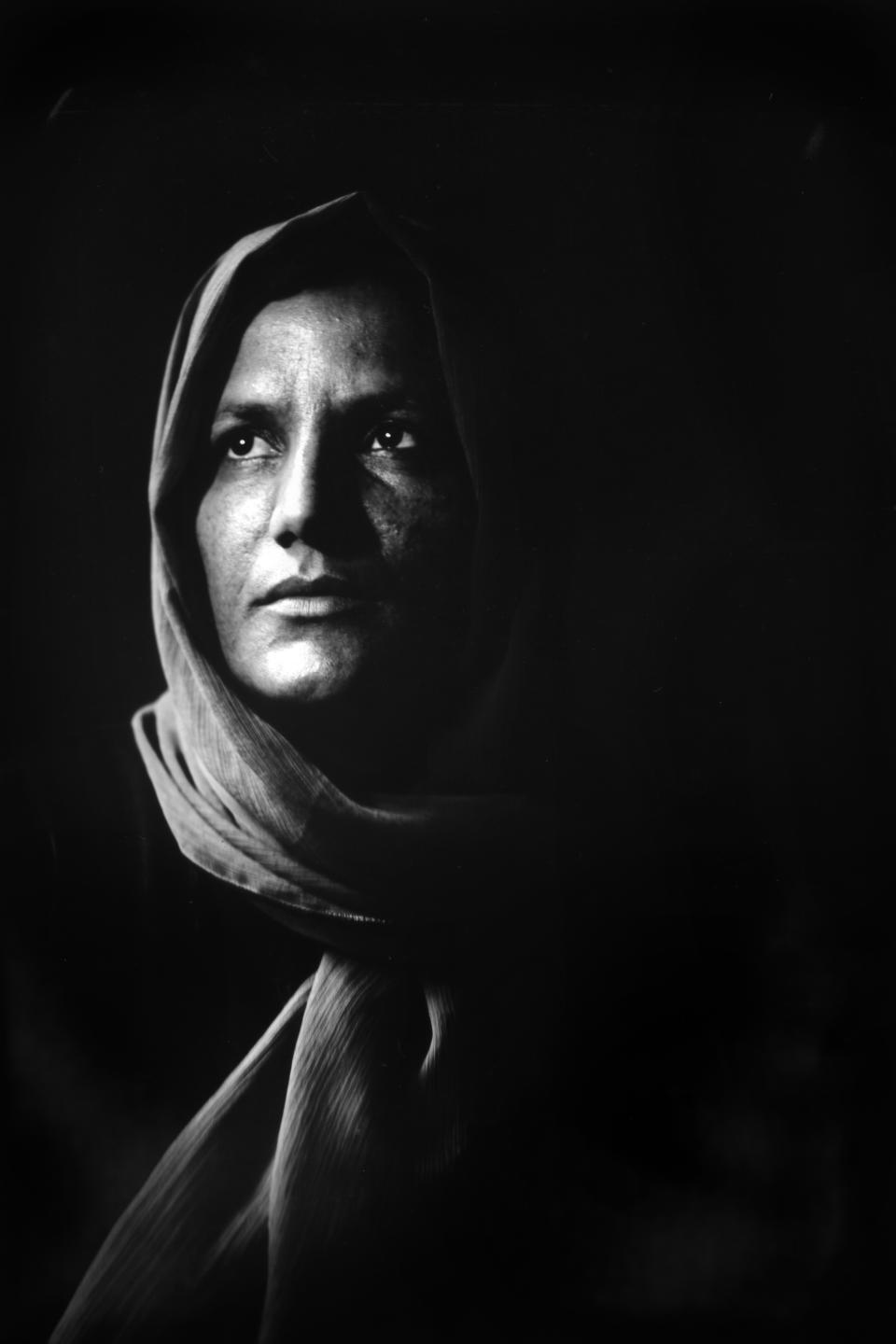 Zermine, 32, poses for a portrait while taking a break from her job in a carpet factory in Kabul, Afghanistan, Monday, May 29, 2023. Zermine has three children. Her husband was killed in a suicide attack by the Taliban five years ago. (AP Photo/Rodrigo Abd)