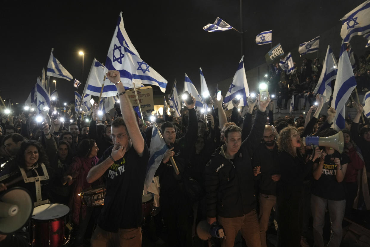 Israelis opposed to Prime Minister Benjamin Netanyahu's judicial overhaul plan protest outside of the Knesset, the country's parliament, after the Israeli leader fired his defense minister, in Jerusalem, Monday, March 27, 2023. Defense Minister Yoav Gallant had called on Netanyahu to freeze the plan, citing deep divisions in the country and turmoil in the military. (AP Photo/ Mahmoud Illean)