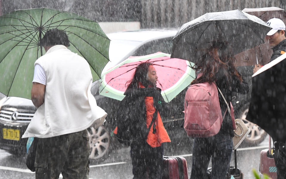 Pedestrians hold umbrellas during wet weather in Sydney on Friday. Source: AAP