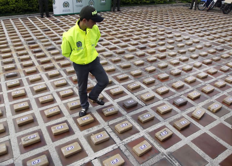 Foto de archivo. Un policía antinarcóticos camina entre paquetes de cocaína incautados en Cali