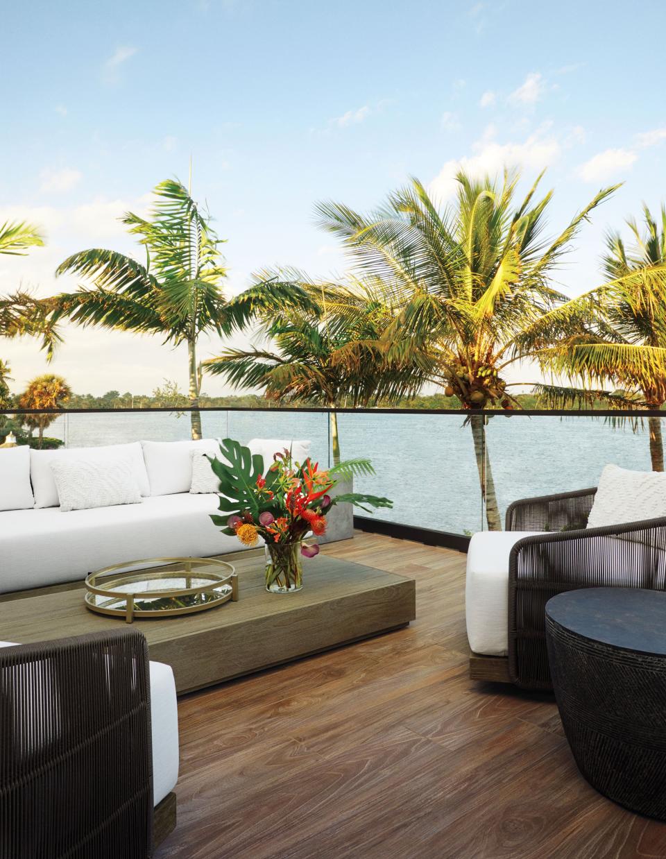A terrace outfitted with RH furniture overlooks the water.