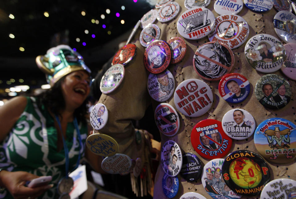 FILE - In this Aug. 26, 2008, file photo, delegate Kelly Jacobs, of Hernando, Miss., shows off her many buttons to Awilda Cordero, a delegate from Bronx, N.Y., left, during the Democratic National Convention in Denver. Viewer interest in the 2012 Republican and Democratic national conventions is still unclear. With the parties' quadrennial presidential nominating gatherings fast approaching, organizers on both sides are bedeviled by a similar challenge: how to ensure TV viewer interest in the multiday affairs, which threaten to be largely predictable spectacles nearly devoid of suspense (AP Photo/Charles Dharapak, File)