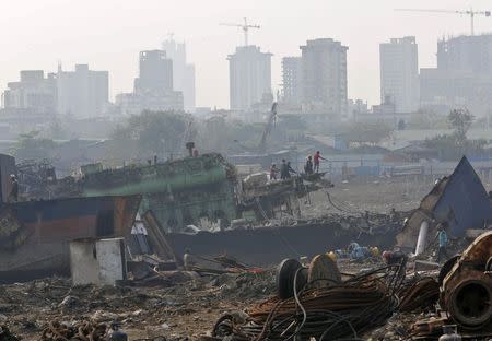 Workers dismantle a ship at a ship breaking yard in Mumbai November 17, 2014. REUTERS/Shailesh Andrade