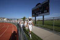 Davis players walk off the field before the start of their high school football game against Herriman on Thursday, Aug. 13, 2020, in Herriman, Utah. Utah is among the states going forward with high school football this fall despite concerns about the ongoing COVID-19 pandemic that led other states and many college football conferences to postpone games in hopes of instead playing in the spring. (AP Photo/Rick Bowmer)