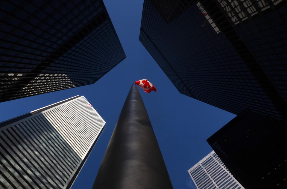 TORONTO, ONT - FEBRUARY 3: A Canadian flag flies in the financial district between the towers of the Toronto-Dominion Center, the Bank of Montreal building and the Canadian Imperial Bank of Commerce headquarters on February 3, 2022, in Toronto, Canada. (Photo by Gary Hershorn/Getty Images)