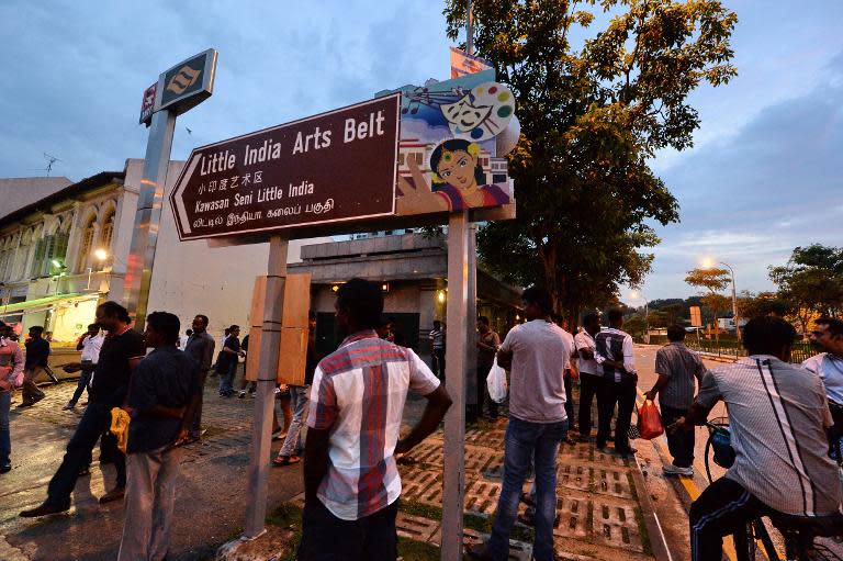 South Asian labourers stand outside a MRT train station after the suspension of sale and consumption of alcohol in the Little India district in Singapore on December 15, 2013