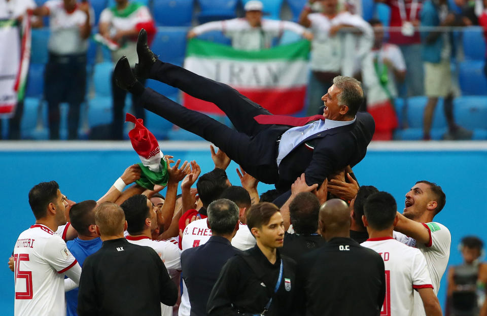 <p>Three cheers: Iran players throw their manager Carlos Quieroz into the air after their win. (REUTERS) </p>