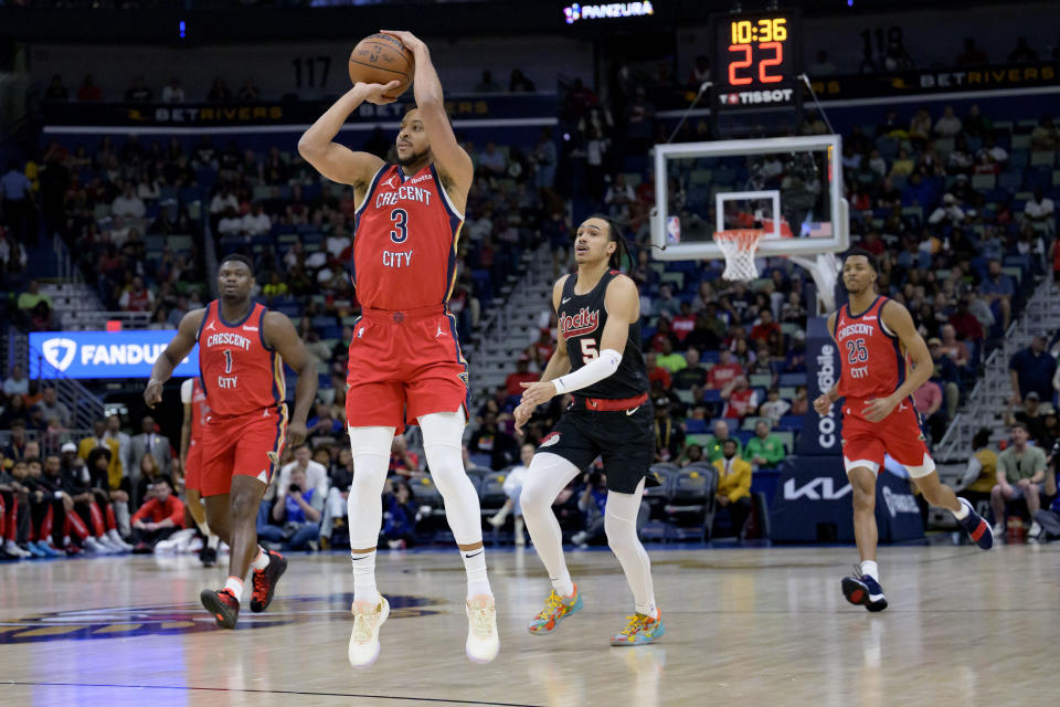New Orleans Pelicans guard CJ McCollum (3) shoots a wide open 3-point basket after making a steal during the first half of an NBA basketball game against the Portland Trail Blazers including guard Dalano Banton (5) in New Orleans, Saturday, March 16, 2024. (AP Photo/Matthew Hinton)