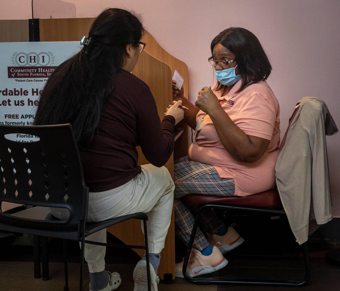 Miami, Florida, December 20, 2023 - Community Health Worker, Ellen Smith, right, helps out a client with insurance questions at the Doris Ison Health Center, 10300 SW 216th Street, Miami, FL 33190