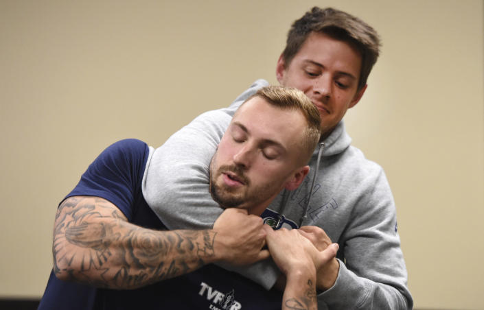 In this photo taken Sept. 10, 2019, Ryan Russo, left, and Mike Herrall go through a drill during a defensive tactic training class at the American Medical Response training center in Clackamas, Ore. Paramedics in Portland are undergoing mandatory training in defensive tactics after a rash of high-profile attacks against them as they respond to 911 calls for people in a mental health or drug-related crisis. (AP Photo/Steve Dykes)