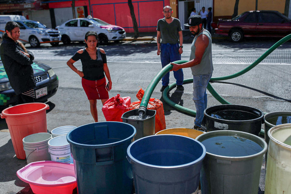 People fill buckets with water from a water tanker truck in the Azcapotzalco neighborhood in Mexico City on Jan. 26, 2024. (Henry Romero / Reuters)