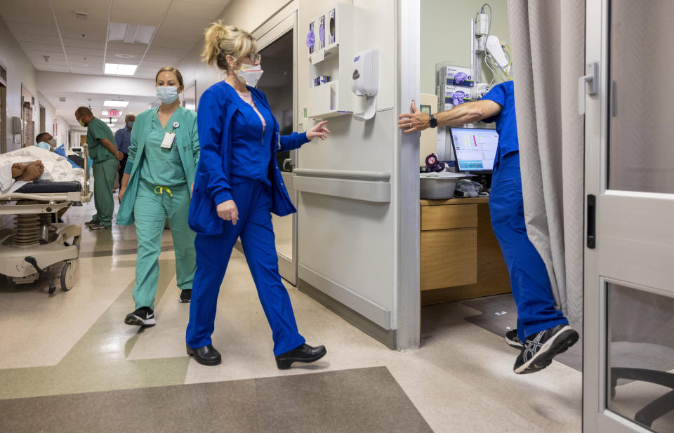 Running from room to room, emergency room director Mark Kellar, right, barely puts one foot down as he hurries between patients at Our Lady of Angels Hospital in Bogalusa, La., Monday, Aug. 9, 2021. (Chris Granger/The Advocate via AP)