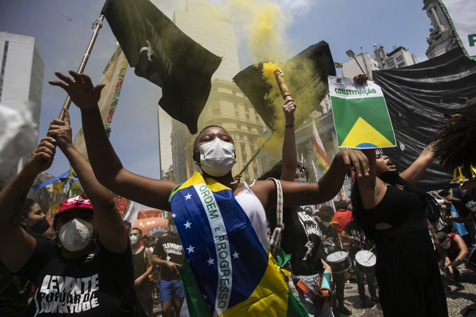 A woman, wrapped in a Brazilian national flag, chats slogans during a protest against Brazilian President Jair Bolsonaro calling for his impeachment over his government's handling of the pandemic and accusations of corruption in the purchases of COVID-19 vaccines, in Rio de Janeiro, Brazil, Saturday, Oct. 2, 2021. (AP Photo/Bruna Prado)